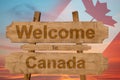 Welcome to Canada sing on wood background with blending national flag