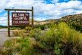 Welcome to Colorful Colorado Sign next to big Yellow Wild Bush