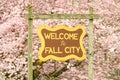Welcome to Fall City sign in Washington with cherry blossom background
