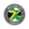 Welcome to Jamaica. Gray stamp with a waving country flag.