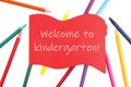 Welcome to kindergarten message on red wood sign with colored watercolor pencils