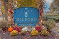 Welcome to Milford, PA, sign on a fall morning decorated with seasonal mums and a pumpkin