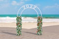 Welcome to 2022 New Year Concept. Beautiful Decor Arc, Gate or Portal with Flowers and 2022 Sign on an Ocean Deserted Coast. 3d