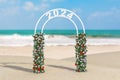 Welcome to 2024 New Year Concept. Beautiful Decor Arc, Gate or Portal with Flowers and 2024 Sign on an Ocean Deserted Coast. 3d