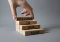 Welcome to our team symbol. Concept words Welcome to our team on wooden blocks. Beautiful grey background. Businessman hand. Royalty Free Stock Photo