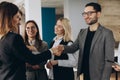 Welcome to our team! Top view of young modern men in smart casual wear shaking hands while working in the creative office Royalty Free Stock Photo