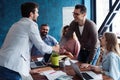 Welcome to our team! Young modern men in smart casual wear shaking hands while working in the creative office. Royalty Free Stock Photo