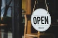 Welcome. vintage wooden OPEN sign board hanging on glass door in modern cafe restaurant Royalty Free Stock Photo