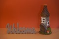 WELCOME wood inscription and fairytale house with copy space. Concept of a home. Invitation to visit. Home comfort