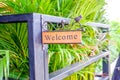 Welcome wooden label in front of the door on natural background