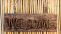 Welcome wooden sign hanging on a rope on bamboo b