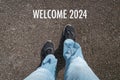 Welcome 2024, word on street in front of woman Royalty Free Stock Photo