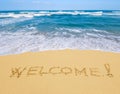 Welcome written in a sandy beach