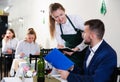 Welcoming female waiter is taking order from businessman in restaurante Royalty Free Stock Photo