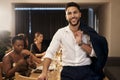 Welcoming the New Year with class. a handsome young man standing and holding his jacket during a New Years dinner party Royalty Free Stock Photo