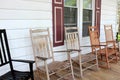Welcoming scene of front porch and several miss-matched Adirondack rocking chairs