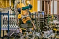 A welder busy welding on a motor vehicle production line with a big industrial welding machine.