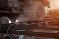 Welder in a car workshop welds a truck frame
