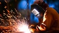 Welder erecting technical steel. He holds a welding machine in his hand and welds the metal structure. Royalty Free Stock Photo