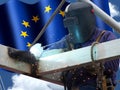 Welder of European Union with his flag in the background Royalty Free Stock Photo