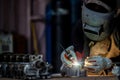 Welder in face mask welds with argon arc stainless steel welding, Industrial worker at the factory welding steel structure, Welder Royalty Free Stock Photo