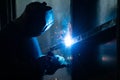 Welder in his workshop welding metal, lots of sparks flying around