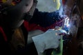 Welder in iron mask helmet welds with electric arc steel welding, Industrial worker at the factory welding steel structure, Welder Royalty Free Stock Photo