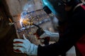 Welder in iron mask helmet welds with electric arc steel welding, Industrial worker at the factory welding steel structure, Welder Royalty Free Stock Photo