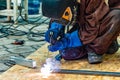 A welder makes a frame from a profile pipe by connecting them with electric welding Royalty Free Stock Photo