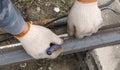 The welder makes measurements marking marker on the steel beam for further work