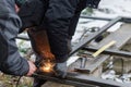 Welder man welding metal iron with electrodes, worker wearing protective helmet and gloves. Close up of electrode welding and Royalty Free Stock Photo