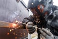 Welder man welding metal iron with electrodes, worker wearing protective helmet and gloves. Close up of electrode welding and Royalty Free Stock Photo