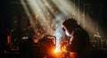 Welder in Protective Gear Working in Dark Environment with Sparks and Light Rays Royalty Free Stock Photo