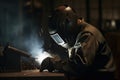 Welder in protective mask welding steel construction at factory. Metalwork and construction concept. An Industrial welder wearing