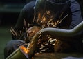 Welder repairing a car exhaust pipe