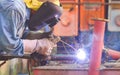 Welder with safety equipment is welding steel pipe for use in oil pipeline system renovate work in tanker ship