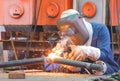 Welder with safety equipment is welding steel pipe at workshop for use in oil pipeline system renovate work in tanker ship Royalty Free Stock Photo