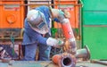 Welder using electric grinder machine to polishing steel pipe for improving oil pipeline system work in tanker ship Royalty Free Stock Photo