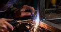 a welder is using a torch to work on a metal structure, causing bright sparks to fly Royalty Free Stock Photo