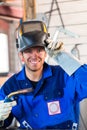 Welder with welding device in metal workshop Royalty Free Stock Photo