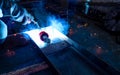 Welder welding metal with argon arc welding machine and has welding sparks. A man wears protective gloves. Safety in industrial Royalty Free Stock Photo