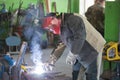 Welder at work. A worker in work clothes is welding an iron part Royalty Free Stock Photo