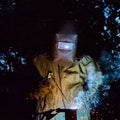 Welder worker welding metal by electrode Royalty Free Stock Photo