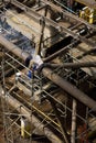 A welder working on a massive steel jacket -the first installed section of an offshore platform High view