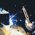 Welder working on a metal structure fixing an urgent problem on the night shift close-up, front and back background blurred with Royalty Free Stock Photo