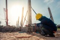 Welder working welding assembly structure between ground beam and pillar prefabricated concrete