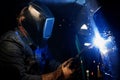 A welder works using welding equipment and makes seams on metal Royalty Free Stock Photo