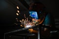 The welder works with a welding arc over a metal structure