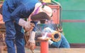 Welders are welding metal flange to connect with steel pipe for use improving oil pipeline systems work in tanker ship