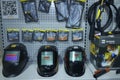 Welding helmets, torch nozzles, gas burners and holders placed on a counter, shop.